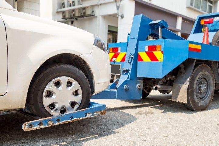Blue tow truck towing a grey vehicle in Cleveland Ohio